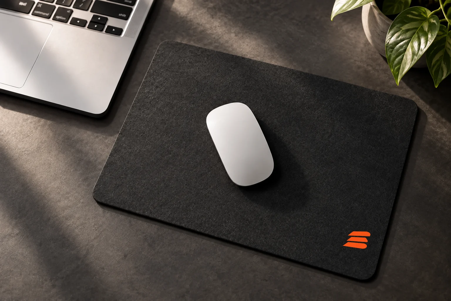 Charcoal Buildside mouse pad with an orange mark beside a laptop